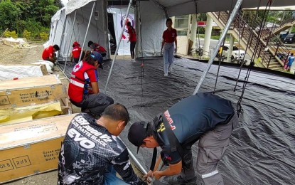 <p><strong>MAKESHIFT HOSPITAL.</strong> The Philippine Red Cross (PRC) and the Davao de Oro Provincial Disaster Risk Reduction and Management Office (PDRRMO) install three tent field hospitals on Sunday (Feb. 5, 2023) to help the damaged Davao de Oro Provincial Hospital (DDOPH) in Montevista town cater to relocated patients. The makeshift facilities are installed inside the compound of the DDOPH that was badly damaged by the Feb. 1 earthquake. <em>(Photo courtesy of Davao de Oro PIO)</em></p>