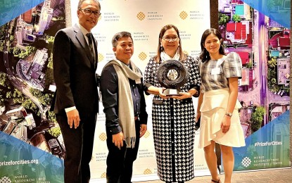 <p><strong>AWARD</strong>. Sonia Cadornigara, regional coordinator of the Homeless People's Federation Philippines, Inc. (HPFPI)-Western Visayas (2nd from right) receives the runner-up trophy for Iloilo City’s Participatory Housing and Urban Development initiative during the 2021-2022 World Resources Institute (WRI) Ross Center Prize for Cities awarding ceremony in New York on Feb. 1, 2023. The initiative showcases the collaboration of urban poor communities under the Iloilo City Urban Poor Network and the city government to respond to issues of informal settlers. <em>(Photo courtesy of New York Philippine Mission)</em></p>