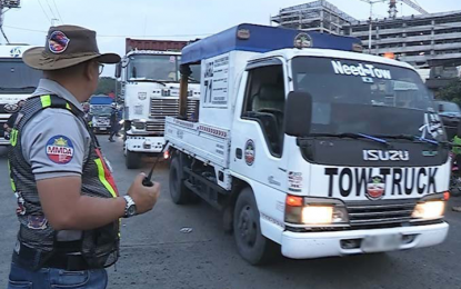 <p><strong>TOWED.</strong> A Metropolitan Manila Development Authority wrecker tows a container truck during clearing operations along Dagupan Extension in Tondo, Manila on Tuesday (Jan. 24, 2023). MMDA Acting Chair Don Artes said criminal and administrative charges will be filed against a barangay chairperson who assaulted an MMDA worker during a clearing operation in the area in late January. <em>(Photo courtesy of MMDA)</em></p>