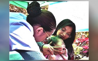 <p><strong>VACCINATION</strong>. A child receives a vaccine during a “Bakunahang Bayan” session in Baguio City in this undated photo. The city government requires parents or guardians of pupils enrolling in daycare centers to submit a vaccination record as a basis for the counseling or possible jab of the child. <em>(PNA file photo)</em></p>