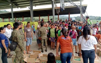 <p><strong>RELIEF AID</strong>. Residents of Barangay Oringao, Kabankalan City, Negros Occidental receive food packs at a gymnasium where they stayed following clashes between government forces and the New People's Army on Sunday (Feb. 5, 2023). An Army official on Tuesday said they target to end the communist insurgency in Negros Oriental by the first quarter of this year. <em>(Courtesy of the Philippine Army)</em></p>