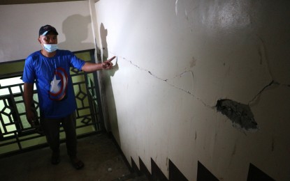 <p><strong>MAJOR DAMAGE.</strong> A worker from the Davao de Oro Provincial Hospital (DDOPH) in Montevista town shows the cracks on a health facility caused by the magnitude 6 earthquake on Feb. 1, 2023. Two areas in the hospital were temporarily declared unsafe. <em>(PNA photo by Robinson Niñal Jr.)</em></p>
