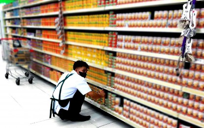 <p><strong>NO SIGNIFICANT ADJUSTMENTS</strong>. A worker arranges canned goods on the shelves in a grocery store in Quezon City in this undated photo. The Philippine Amalgamated Supermarkets Association on Tuesday (Dec. 5, 2023) said suppliers of basic commodities have not made significant adjustments to the prices of their goods. <em>(PNA photo by Ben Briones)</em></p>