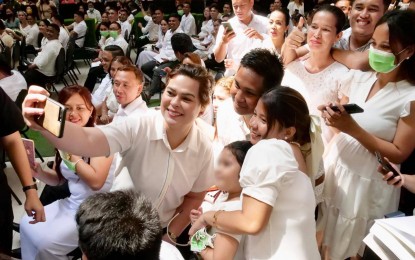 <p><strong>NEWLYWED COUPLES</strong>. Vice President Sara Duterte poses for a "groufie" with newlywed couples in Parañaque City during the 62nd "Pa-Wedding ni Tambunting" (free mass wedding) on Tuesday (Feb. 14, 2023). She urged them to practice family planning to spare children from poverty. <em>(Photo courtesy of the Office of the Vice President) </em></p>