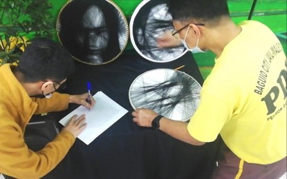 <p><strong>STRING ART</strong>. A person deprived of liberty at the Baguio City Jail Male Dorm (BCJMD) creates an artwork using colored threads on Tuesday (Feb. 14, 2023). String art (or "pin and thread" art) is among the activities being promoted by the BCJMD among the inmates at the facility. <em>(PNA photo by Liza T. Agoot)</em></p>