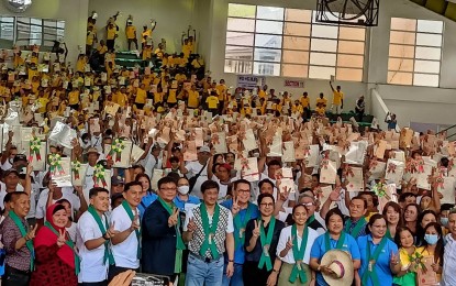 <p><strong>TENURED</strong>. Agrarian Reform Beneficiaries from Western Visayas wave their land titles in a photo with the Department of Agrarian Reform Family on Friday (Feb. 17, 2023). Agrarian Reform Secretary Conrado M. Estrella III led the distribution of 2,358 titles to 1,500 ARBs from Antique, Capiz, Guimaras, Iloilo and Negros Occidental and turnover of PHP114.357 million worth of farm machinery and equipment under the Sustainable and Resilient Agrarian Reform Communities project benefitting 4,033 ARBOs in the region. <em>(PNA photo by PGLena)</em></p>