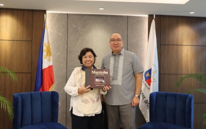 <p>Department of Migrant Workers Secretary Susan Ople (left) with Manitoba Minister of Labour and Immigration Jon Reyes during a courtesy call on Wednesday (Feb. 22, 2023) at the DMW office in Mandaluyong City.  <em>(Photo courtesy of DMW) </em></p>