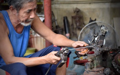 <p><strong>SCRAP METAL ARTIST.</strong> Denis Fernandez, 55, a mechanic, welds scrap metals to form art pieces in this undated photo in Pozorrubio town, Pangasinan province. He started his hobby in 2016 and has now over 100 scrap metal art pieces. <em>(Photo courtesy of Denis Fernandez)</em></p>