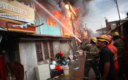 <p><strong>BRAVING THE FIRE.</strong> Firefighters try to stop the blaze from spreading in Purok 8-A, Barangay 21-C, Davao City on Saturday afternoon (Feb. 25, 2023). An estimated PHP9 million worth of properties were damaged, including 1,200 houses. <em>(PNA photo by Robinson Niñal Jr.)</em></p>