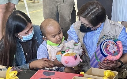<p><strong>CRUCIAL ROLE</strong>. Department of Health officer-in-charge Undersecretary Maria Rosario Vergeire hands over gifts to a cancer patient at the covered court of Mariano Marcos Memorial Hospital and Medical Center in Batac City, Ilocos Norte on Friday (March 3, 2023). Vergeire highlighted the crucial roles of primary care and specialty care services to support the government's universal healthcare program. <em>(PNA photo by Leilanie G. Adriano)</em></p>