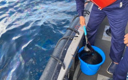 <p><strong>OIL SPILL.</strong> A Philippine Coast Guard (PCG) personnel siphons ocean water mixed with oil in Oriental Mindoro for evaluation in this undated photo. The Office of Civil Defense on Saturday (March 2, 2024) emphasized the need for a better oil spill response a year after MT Princess Empress loaded with 800,000 liters of industrial fuel oil sank off Naujan town, Oriental Mindoro province on Feb. 28, 2023. <em>(Photo courtesy of PCG)</em></p>