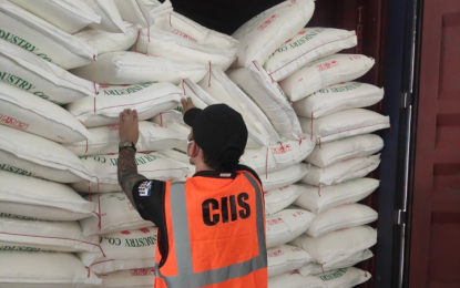 <p><strong>SMUGGLED.</strong> A personnel of the Customs Intelligence and Investigation Service examines sacks of smuggled sugar and onions in this undated photo. The Bureau of Customs on Sunday (March 5, 2023) said it found smuggled agricultural products worth PHP101.6 million in 17 shipments at the Manila International Container Port during inspections on Feb. 27 and 28. <em>(Courtesy of BOC)</em></p>