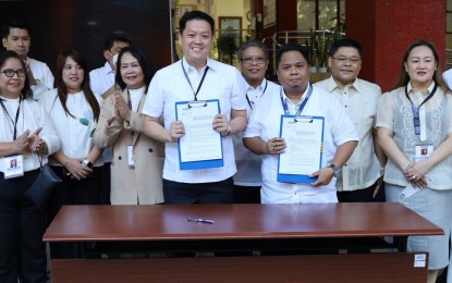 <p><strong>BENEFITS</strong>. Department of Social Welfare and Development (DSWD) Secretary Rex Gatchalian and Social Welfare Employees’ Association of the Philippines representative Anthony Septimo present the newly-signed administrative orders for the implementation of the grant of each Magna Carta benefit to public social workers and hazard pay for public social welfare and development workers during the agency’s flag ceremony at the DSWD central office on Monday (March 6, 2023). Also in photo are DSWD executive and management committee members. (Photo from DSWD website)</p>