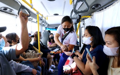 <p>A modern jeepney conductor hands over change to a passenger on March 7, 2023. <em>(PNA photo by Joey O. Razon)</em></p>