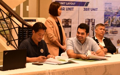 <p><strong>PARTNERSHIP</strong>. Bacolod City Mayor Alfredo Abelardo Benitez (left) and William Russell Scheirman Jr. (seated, center), president and chief executive officer of Scheirman Construction Consolidated Inc. (SCCI), sign the joint venture agreement for the PHP2-billion mixed-use human settlement project to be developed by the consortium of WRS Holdings Inc. and SCCI, at the Government Center lobby on Tuesday night (March 7, 2023), in the presence of city officials, including Councilor Vladimir Gonzales (right) chairman of the City Council’s committee on urban poor, housing resettlement. The agreement will include the development of up to 20,000 housing units in line with the implementation of the Pambansang Pabahay para sa Pilipino Program. <em>(Photo courtesy of Bacolod City PIO)</em></p>