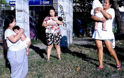 <p class="p1"><strong>MOTHER'S LOVE.</strong> Three mothers sunbathe their babies early morning along a sidewalk in Barangay Old Capitol Site in Quezon City on March 8, 2023. The National Authority for Child Care on Tuesday (June 18, 2024) said five of Facebook pages being used to sell babies are still active and two new accounts were created. <em>(PNA photo by Ben Briones)</em></p>