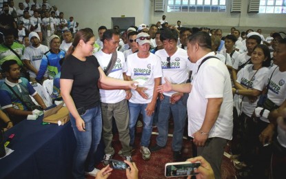 <p><strong>ACCIDENT INSURANCE.</strong> Dumper PTDA Rep. Claudine Diana Bautista-Lim (in black) hands over the accident insurance cards to the tricycle driver beneficiaries in Malita, Davao Occidental, on Friday (March 10, 2023). At least 400 tricycle drivers in the area benefited from the program.<em> (PNA photo by Robinson Niñal Jr.)</em></p>