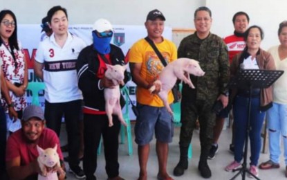 <p><strong>LIVELIHOOD AID</strong>. Some of the former rebels in Escalante City, Negros Occidental province receive piglets for swine raising as livelihood assistance from the city government at the city’s Event Center on Thursday (March 9, 2023). The turn-over rites were witnessed by Lt. Col. J-jay Javines, commander of the 79th Infantry Battalion (3rd from right), Councilor Leo Alejandro Yap (2nd from left), and Sharon Cadigal (1st from left) of the Department of the Interior and Local Government. <em>(Photo courtesy of 79th Infantry Battalion, Philippine Army)</em></p>