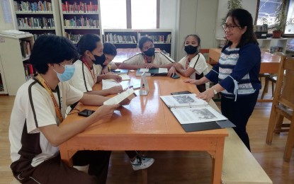 <p><strong>READING</strong>. Antique Provincial Librarian Grace Magullado (right) briefs learners about the various services of their library. Magullado said on Monday (March 13, 2023) they will be conducting a storytelling program for moms as part of the 64th Public Library Day on March 16. <em>(PNA photo by Annabel Consuelo J. Petinglay)</em></p>