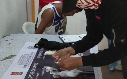 <p><strong>DRUG HAUL</strong>. A police operative conducts an inventory of the shabu seized during a buy-bust in Barangay 27, Bacolod City on Tuesday (March 14, 2023). Suspect Mark Salmingo, 26, yielded 150 grams of the prohibited substance valued at PHP1.02 million. <em>(Photo courtesy of PNP DEG Special Operations Unit-6)</em></p>