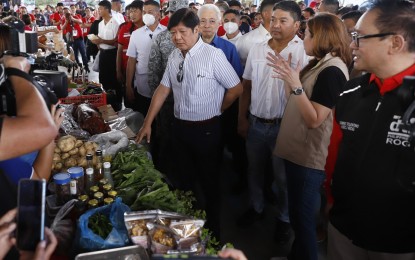 <p><strong>'KADIWA NG PANGULO'.</strong> President Ferdinand R. Marcos Jr. (center) inspects food and agriculture products at the Kadiwa ng Pangulo caravan in Pili, Camarines Sur on Thursday (March 16, 2023). In his speech, Marcos reiterated his promise to reduce the price of rice to PHP20 per kg. <em>(PNA photo by Alfred Frias)</em></p>