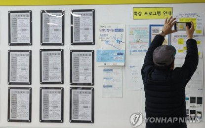 <p><strong>SENIOR BUT ACTIVE.</strong> An elderly man takes a photo of job information on the bulletin board at an employment center in Mapo, western Seoul, on March 15, 2023. <em>(Yonhap)</em></p>