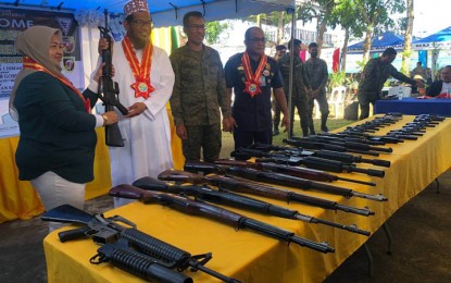 <p><strong>LOOSE GUNS.</strong> Mayor Nursiya Ismael of Lantawan town, Basilan province, hands over 34 loose firearms to military authorities in a ceremony Monday (March 20, 2023), at the headquarters of the 19th Special Forces Company in Isabela City, the province's capital. Brig. Gen. Domingo Gobway, commander of Joint Task Force (JTF)-Basilan, said the firearms were surrendered by residents from different barangays of Lantawan town. <em>(Photo courtesy of JTF-Basilan)</em></p>