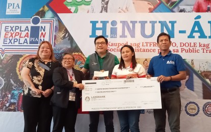 <p><strong>LIVELIHOOD AID</strong>. Romelie Soliguen (2nd from right), chairperson of United Negros Transport Cooperative, receives the PHP1-million check as livelihood assistance under the EnTsuperneur Program of the Department of Transportation and the Department of Labor and Employment (DOLE), from DOLE-Negros Occidental head Carmela Abellar (2nd from left), during the "Hinun-anon," an information campaign event of the Philippine Information Agency (PIA) on the social assistance for public transport workers, held at the Green Garden in Bacolod City on Wednesday afternoon (March 22, 2023). Witnessing the turnover are Undersecretary Ramon Lee Cualoping III (center) and Assistant Secretary Katherine Chloe de Castro (left), PIA director general and deputy director general, and John Mandario, labor communications operations officer of DOLE-Western Visayas. <em>(PNA photo by Nanette L. Guadalquiver)</em></p>