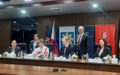 <p><strong>OFFSHORE WIND.</strong> Energy Secretary Raphael Lotilla (seated, second from left) and Copenhagen Infrastructure Partners (CIP) association partner Przemek Lupa (seated, third from left) sign the service contracts for three offshore wind energy projects in the country at the Department of Energy office in Taguig City on Thursday (March 30, 2023). CIP is the first foreign company that will develop renewable energy (RE) projects in full ownership since the Marcos administration lifted foreign ownership restrictions in the RE sector.<em> (PNA photo by Kris M. Crismundo)</em></p>