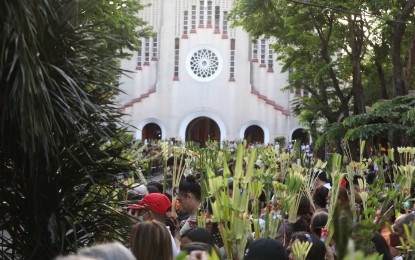 <p><strong>PALM SUNDAY.</strong> Catholics raise their “palaspas” for the blessing with holy water outside Baclaran Church in Parañaque City on Palm Sunday (April 2, 2023). The occasion marks the start of the Holy Week, symbolizing the triumphant entry of Jesus Christ into Jerusalem. <em>(PNA photo by Avito Dalan)</em></p>