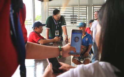 <p><strong>SIM REGISTRATION.</strong> Nelson Cañete (center), director of the National Telecommunications Commission-Davao Region, personally oversees the remote SIM registration in Sta. Maria, Davao Occidental, on Tuesday (April 4, 2023). He calls on residents to register their SIM cards before the April 26 deadline. <em>(PNA photo by Robinson Niñal Jr.)</em></p>