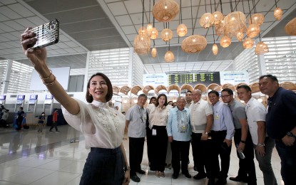 <p><strong>ALL SMILES.</strong> Tourism Secretary Christina Frasco (left) takes a group photo with Transportation Secretary Jaime Bautista (3rd from left) and other officials on Tuesday (April 4, 2023). Frasco and Bautista led an ocular inspection of the terminals of the Ninoy Aquino International Airport (NAIA) for the Holy Week exodus, as well as to check the status of development projects at the airport. <em>(PNA photo by Avito Dalan)</em></p>