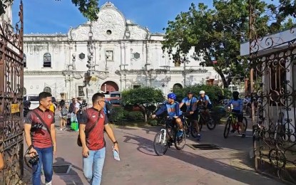 <p><strong>BISIKLETA IGLESIA.</strong> Police Regional Office-Central Visayas deputy director for operations, Col. Noel Flores (front, in bike) leads other police officers in the "Biseklita Iglesia" at the Cebu Metropolitan Cathedral on Thursday morning (April 6, 2023). The activity was part of the Philippine National Police's peace and order campaign during the observance of the Holy Week. <em>(Screengrab from PRO-7 PIO video)</em> </p>