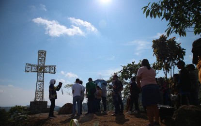 <p><strong>PILGRIMAGE.</strong> Devotees pray at the end of the Stations of the Cross at Majestic Peak in Barangay Marahan Marilog District, Davao City on Maundy Thursday (April 6, 2023). The peak is on a 2.8-hectare land converted into a haven for devotion. <em>(PNA photo by Robinson Niñal Jr.)</em></p>