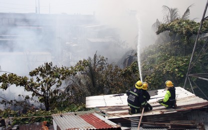 <p>Quezon City firefighters worked tirelessly to quell a fire that consumed residential houses in Barangay South Triangle on April 23, 2023. The blaze reached the first alarm. <em>(PNA photo by Robert Oswald P. Alfiler) </em></p>