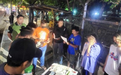 <p><strong>STING OPERATION.</strong> Suspect Romina Ramas Perez covers her face while the Philippine Drug Enforcement Agency (PDEA) agents conduct an on-site inventory of the PHP10.2-million worth of drugs as evidence. Perez was arrested in an anti-narcotics sting operation in Maguikay, Mandaue City on Black Saturday (April 8, 2023). <em>(Photo courtesy of PDEA-7)</em></p>