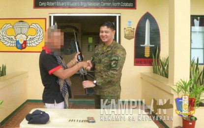 <p><strong>NEW LIFE.</strong> A New People’s Army (NPA) guerilla identified only as 'Pilo' hands over his rifle to Lt. Col. Ranier Mabus, commanding officer of the 1st Scout Ranger Battalion, during a surrender rite at the battalion headquarters in Carmen, North Cotabato, on Thursday (April 13, 2023. A day earlier, another rebel identified only as 'Takla' also turned himself in in Maasim town, Sarangani province.<em> (Photo courtesy of 6ID)</em></p>