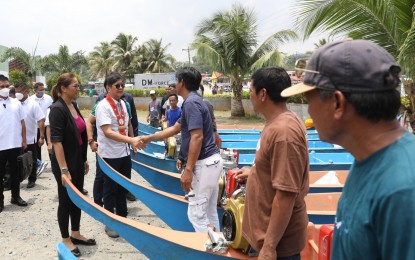 <p><strong>FISHING BOATS DISTRIBUTED</strong>. President Ferdinand R. Marcos Jr. shakes hands with a resident while leading the turnover of fishing boats to the province of Oriental Mindoro with Pola Mayor Jennifer M. Cruz (left) on Saturday (April 15, 2023). The Chief Executive presided over the situation briefing and distribution of various government assistance to more than 1,200 beneficiaries in the municipality of Pola.<em> (PNA photo by Alfred Frias)</em></p>