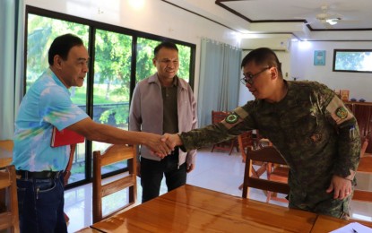<p><strong>FEUD SETTLEMENT.</strong> Brig. Gen. Donald Gumiran (right), Army’s 602nd Infantry Brigade commander, welcomes Tuesday (April 18, 2023) Butch Malang (left), chair of the Moro Islamic Liberation Front (MILF) ceasefire panel, and Anwar Alamada (center), also from MILF ceasefire committee, at the 602nd IBde headquarters in Carmen, North Cotabato. The three worked together for the settlement of a clan war that involved MILF members in adjacent Pagalungan town, Maguindanao del Sur province. <em>(Photo courtesy of 602nd IBde)</em></p>