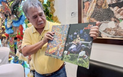 <p><strong>ARTWORKS</strong>. Cadiz City Mayor Salvador Escalante Jr. shows the front and back covers of the city’s coffee table book “Las Pintas (The Paintings)” during the launching in Bacolod City on Thursday (April 20, 2023). It features more than 400 artworks, depicting the way of life in northern Negros City and the neighboring Sagay City and Manapla town in the second district of Negros Occidental. <em>(PNA photo by Nanette L. Guadalquiver)</em></p>