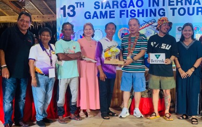 <p><strong>BIG WINNER.</strong> Former Surigao del Norte governor Francisco Matugas (3rd from right) awards the grand prize to Santiago Gonzales (4th from right), who emerged as the big winner during the awarding ceremony on Sunday evening (April 23, 2023) at the conclusion of the 13th Siargao International Game Fishing Tournament in the town of Pilar, Siargao Island. Local officials joined Matugas during the ceremony. <em>(PNA photo by Alexander Lopez)</em></p>