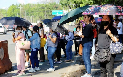 <p><strong>HEALTH HAZARD.</strong> Commuters on their way to work wait for a ride under intense heat along Elliptical Road in Quezon City on April 20, 2023. The Department of Labor and Employment on Friday (March 22, 2024) reminded employers to observe health and safety measures to prevent and control heat stress and minimize its impact at the workplace. <em>(PNA file photo by Joan Bondoc)</em></p>