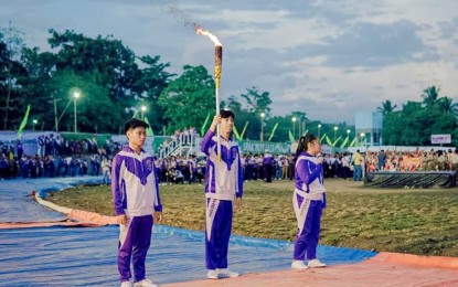 <p><strong>SRAA FLAME.</strong> Three young athletes prepare to run toward the torch, marking the opening of the Soccsksargen Regional Athletic Association Sports Meet in Kidapawan City, North Cotabato on Monday (April 24, 2023). At least 5,000 athletes and coaches are participating in the annual regional sports event. <em>(Photo courtesy of Kidapawan-CIO)</em></p>