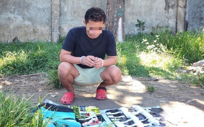 <p><strong>PROBATIONER.</strong> Noel Petecio Jr., a 23-year-old probationer, looks at the packs of shabu seized from him after his arrest in Purok Mayor, Barangay San Roque in Talisay City on Thursday (April 27, 2023. Talisay City police chief Lt. Col. Randy Caballes said Petecio was already arrested by the Sawang Calero Police Station in Cebu City in 2019 but availed of the plea bargaining agreement. <em>(Photo courtesy of Decemay Padilla)</em></p>