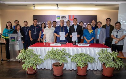 <p><strong>LOAN PAYMENTS.</strong> GSIS acting Executive Vice President Joseph Philip Andres (center, in black suit) and USSC chief finance and administrative officer Carlos Borromeo (center, in blue polo barong) show the signed memorandum of agreement formally granting access to GSIS members to pay their loans via the 800 USSC outlets across the country. They are joined by their fellow executives and employees on Tuesday (April 25, 2023) at the GSIS Head Office.<em> (Photo courtesy of GSIS)</em></p>