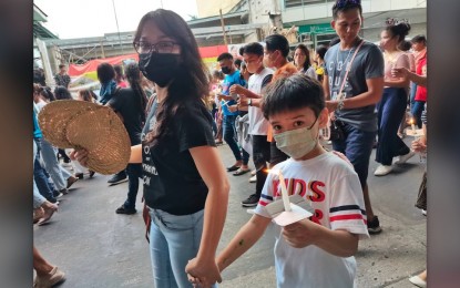 <p><strong>SAFETY NET</strong>. A mother and her son wear face masks while attending the Good Friday procession in Dumaguete City on April 7, 2023.  Provincial Health Officer Dr. Liland Estacion on Thursday (April 27, 2023) appealed to the public to continue wearing face masks as Covid-19 cases in Negros Oriental spiked significantly this week. <em>(Photo by Judy Flores Partlow) </em></p>