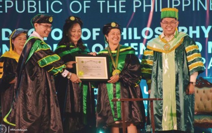 <p><strong>HONORIS CAUSA.</strong> Dr. Samson Molao (left), president of the Sultan Kudarat State University, confers the Doctor of Philosophy in Institutional Development and Management–Honoris Causa on First Lady Liza Araneta-Marcos (2nd right) at the university gymnasium in Tacurong City on Thursday (April 27, 2023). The university describes the honoree as a staunch supporter of education and international dialogue to foster harmony. <em>(Photo courtesy of SKSU)</em></p>