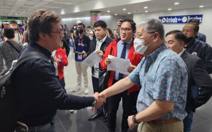 <p><strong>BACK HOME.</strong> Foreign Affairs Secretary Enrique Manalo shakes hands with an overseas Filipino worker who came home from Sudan in this undated photo. Over 700 Filipinos have fled the war-torn African nation since conflict broke out last month. <em>(Photo courtesy of DFA)</em></p>