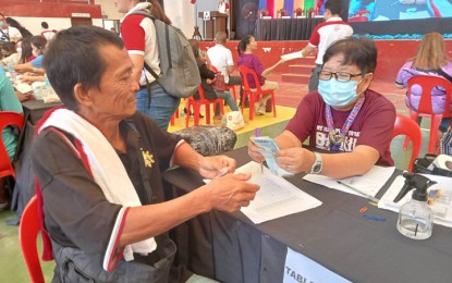 <p><strong>EMERGENCY EMPLOYMENT.</strong> A recipient of emergency employment through the Tulong Panghanapbuhay para sa Disadvantaged/Displaced (TUPAD) workers program (left) receives his salary at the Zamboanga Peninsula Polytechnic State University gymnasium on Monday (May 1, 2023). The Department of Labor and Employment-9 has so far released some PHP43.5 million livelihood and employment assistance coinciding with the Labor Day celebration. <em>(PNA photo by Teofilo P. Garcia Jr.)</em></p>