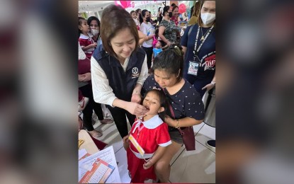 <p><strong>CHIKITING LIGTAS</strong>. Corazon Flores, regional director of the Department of Health Central Luzon Center for Health Development (DOH CLCHD), gives a dose of oral polio vaccine to a child during the kick-off ceremony of the Measles-Rubella Oral Polio Vaccine Supplemental Immunization Activity (MR-OPV SIA) at Waltermart in Barangay San Agustin, City of San Fernando, Pampanga province on Tuesday (May 2, 2023). Flores encouraged parents to bring their children nine to 59 months old to the nearest immunization post to receive measles, rubella, and polio supplemental vaccines. <em>(Photo courtesy of the DOH CLCHD)</em></p>